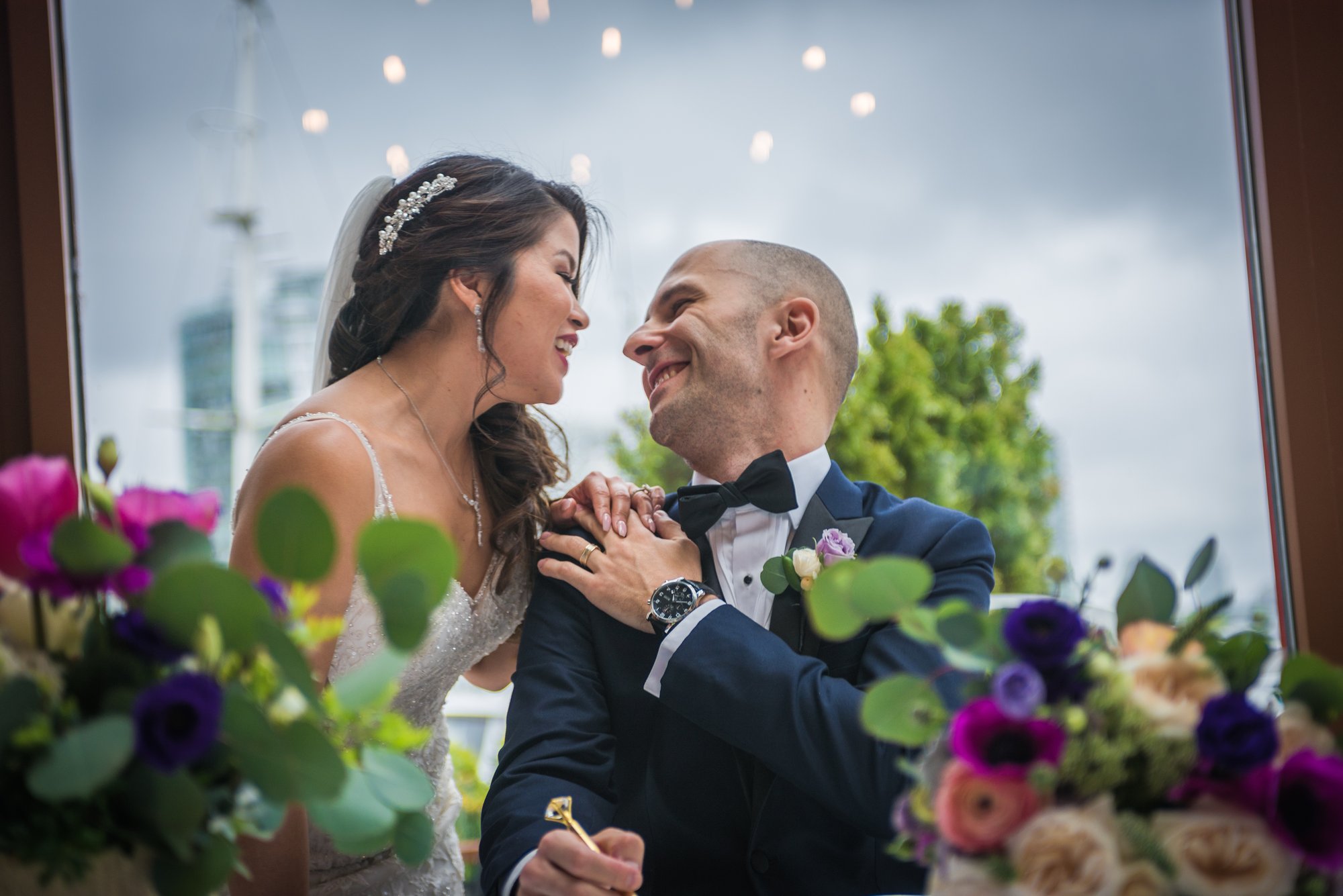 Ozzy and Jessica kissing under a white umbrella in the rain in Vancouver